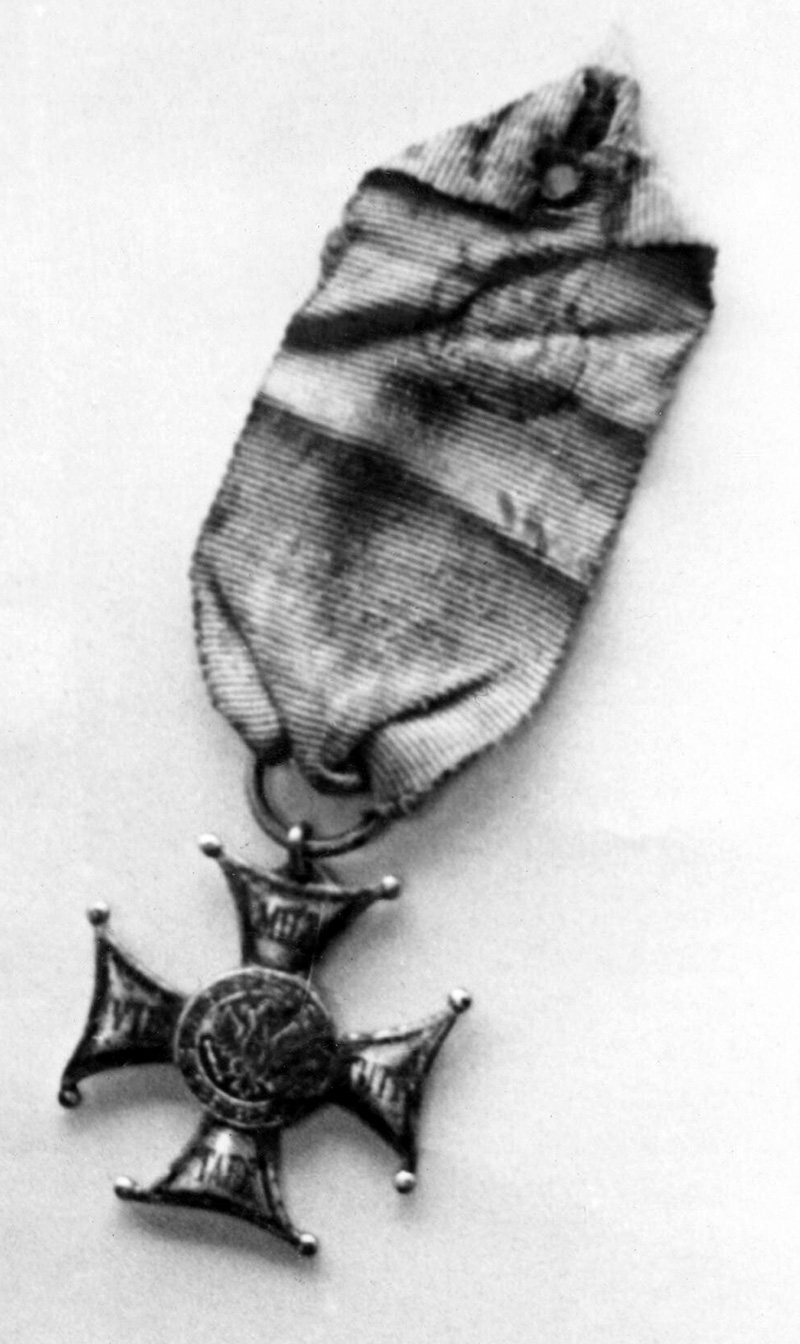 Krzyż Srebrny Orderu Virtuti Militari odnaleziony w jednym z masowych grobów w Katyniu, zdjęcie z 30 kwietnia 1943 r. Źródło: domena publiczna